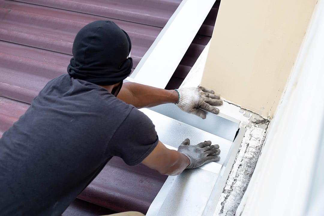 Roof repair, Worker with steel sheet. Stop a roof leak