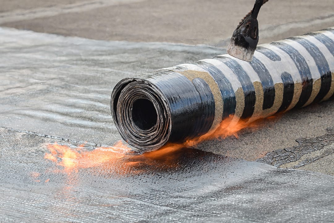 Roofing installation felt with heating and melting bitumen roll by torch on flame.