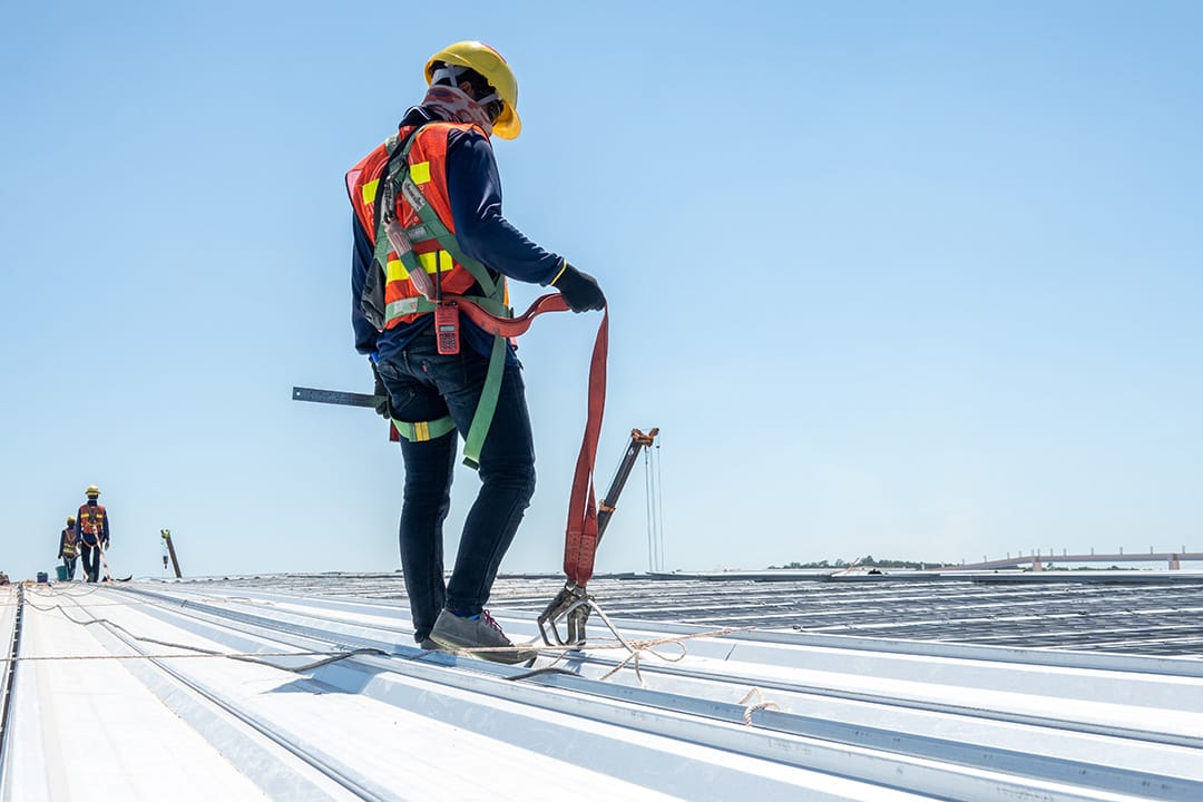 Construction worker wearing PPE woking at roof