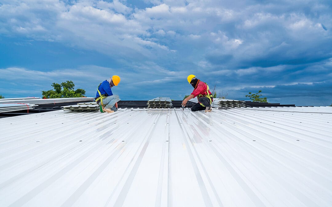 Teamwork of Roofer working at new roof under construction. Safety body construction, Fall arrestor device for worker with hooks for safety body harness on the roof structure.