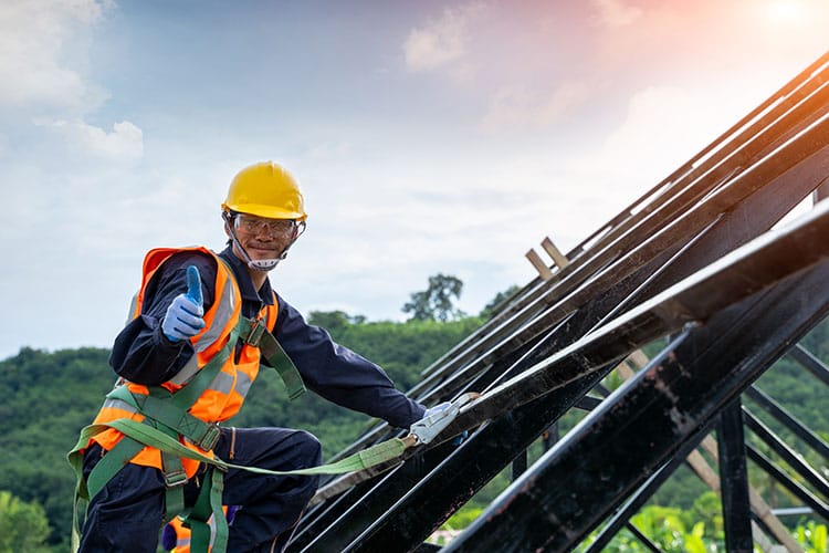 Professional and qualified roofer in protective uniform wear installing metal roof on commercial roof