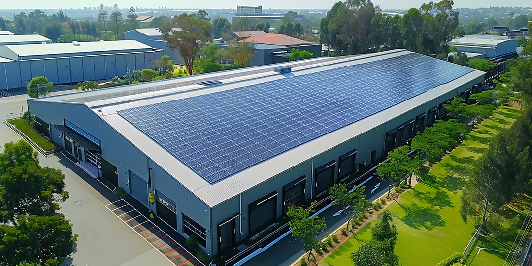 Solar panels installed on the roof of a modern warehouse. Aerial view.