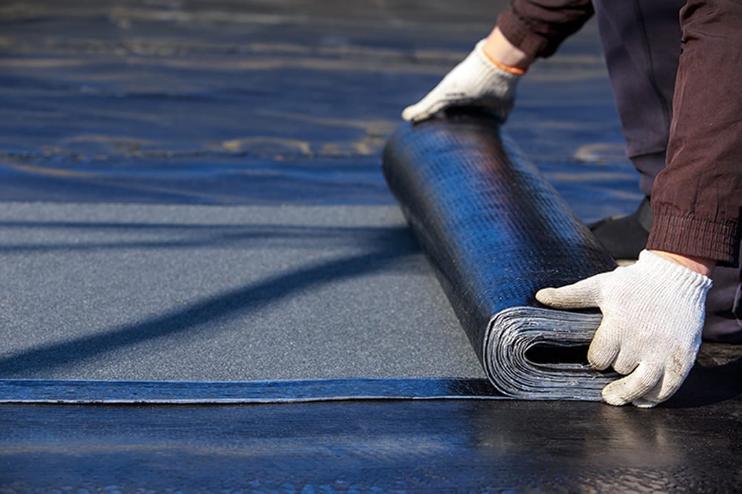 Worker puts roofing material in the open air. Commercial rooring materials.