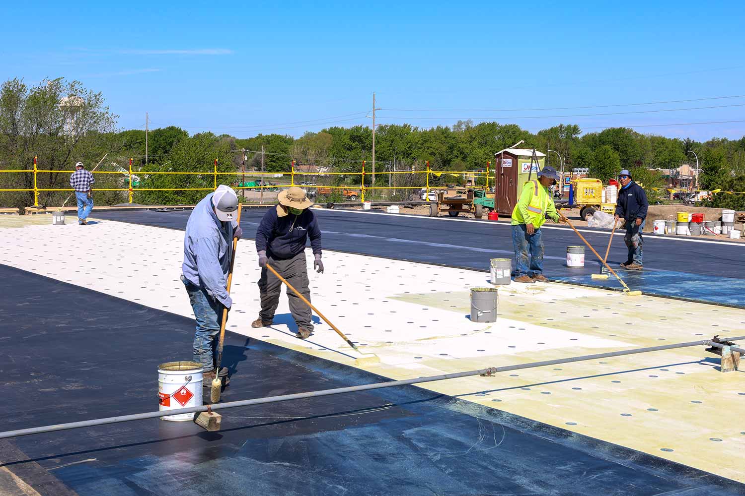 Professional and qualified roofer in protective uniform wear installing metal roof on commercial roof